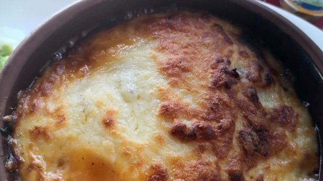 Hot Moussaka dish made in a ceramic pot. Homemade Greek traditional dish.