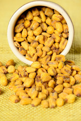 roasted and salted corn in ceramic pot over yellow jute