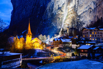 Fototapeta na wymiar amazing touristic alpine village at night in winter with famous church and Staubbach waterfall Lauterbrunnen Switzerland Europe