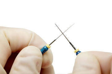 dental instruments for endodontic treatment of teeth in the hands of a dentist isolated on a white...
