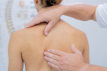 Young woman receiving shoulder massage in a physiotherapy center