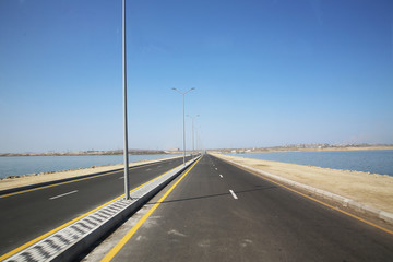 road under a blue sky with focus to the center white line . asphalt car road .wallpaper landscape...
