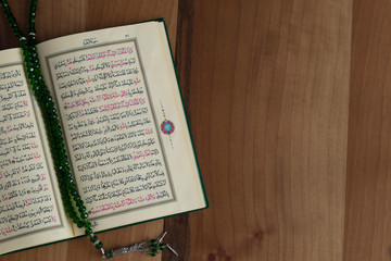 Quran and rosary beads on the wooden background for Islamic concept. Holy book Koran for Muslims holiday, Ramadan,blessed Friday message