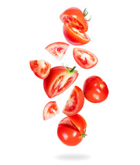 Whole and sliced fresh tomatoes fall down on a white background - obrazy, fototapety, plakaty