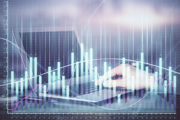 Double exposure of businessman's hands with laptop and stock market graph background. Concept of research and trading.