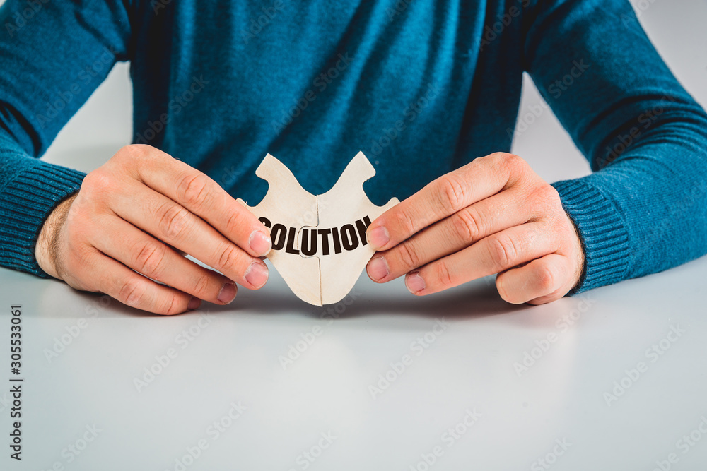 Poster the man is holding matching blocks with the word solution in his hands. the concept of solving probl