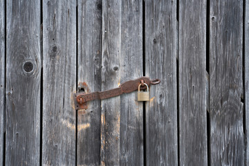 Wooden shelter door with rusty padlock