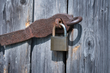 Close up of a rusty padlock at a weathered shelter door