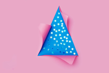 confetti in the form of stars in triangular Torn hole and ripped of paper in a shape of Christmas tree. Christmas flat lay