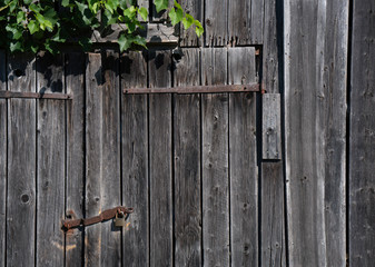 Detail of a rusty padlock at weathered wooden planks