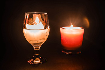 glass with a burning candle