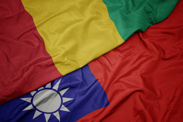 waving colorful flag of taiwan and national flag of guinea.