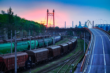 railroad transportation, freight cars in industrial seaport at sunset