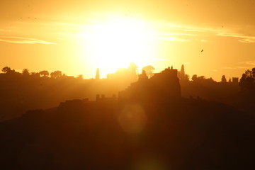 Fez in a beautiful sunset and the sun in the background in some buildings. Morocco