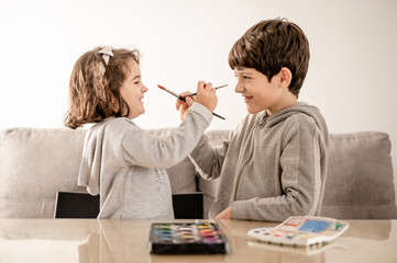 Brothers playing face painting with watercolor