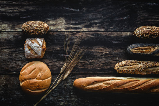 Gold assortment bread homemade on dark wood background, captured from above top view, flat lay in knolling concept