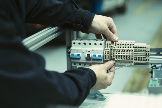 Crop electrician with tool checking switchgear