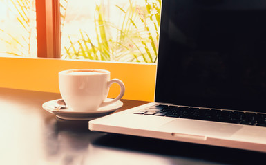 cup of coffee and laptop on table