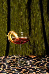 Elegant cocktail on ocelot patterned retro table top, with heavy dark green carpet behind. Abstract conception. - 305541014