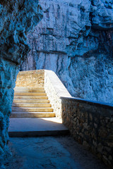 the sun illuminates the stairs to go down to the grotto of neptune at Capo Caccia near Alghero, Sardinia, Italy