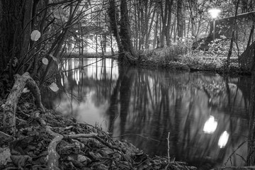a black and white photograph of a river landscape in the darkness