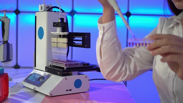 Young woman use Automated DNA Processor real-time PCR cycler.  PCR robotic machine for molecular and genetic research laboratory