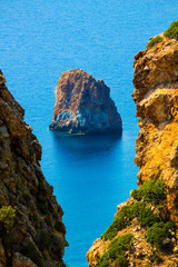 view between two crevasses of a rock on the coast of Sardinia near the pan di zucchero, Italy