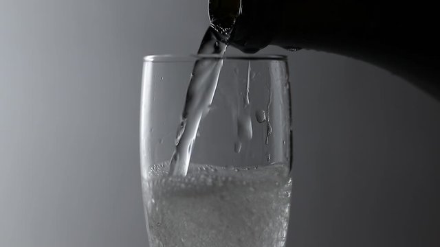 alcohol is poured from a bottle into a glass