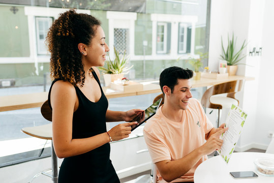 Friends making order in modern cafe