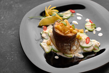 Grilled trout fillet with vegetables, on black background