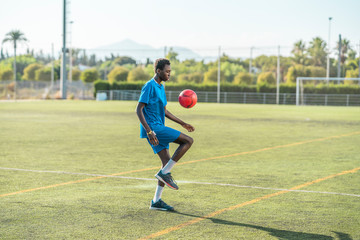 Ethnic teenager juggling football ball