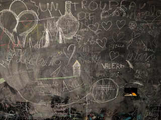 blackboard full of drawings and writings made by children