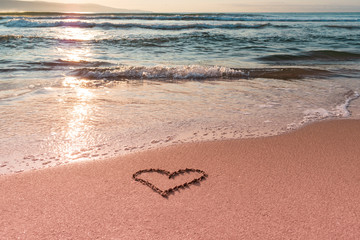 Valentine's day on the beach. Heart on the beach on the sand. Travel and holidays concept. Space for text.