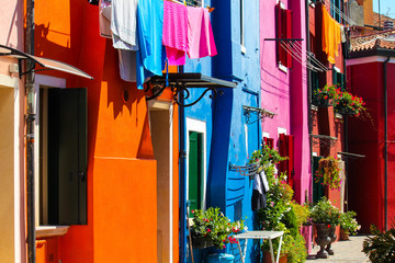 typical alley with colorful houses and flowers in Burano, Venice, Italy