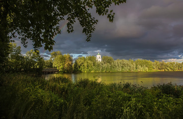 Summer landscape with a Christian church by the river