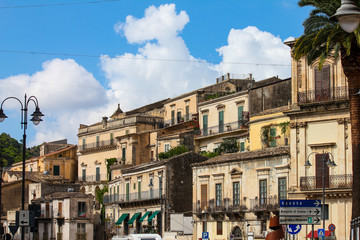 Fototapeta na wymiar Modica, Italy - August 18, 2018: some old houses on a summer day in the town of Modica in Sicily, Italy