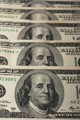 American dollar bills. Fragment of the central parts of notes. Banknotes go one after another. Image of Benjamin Franklin. Vertical photo