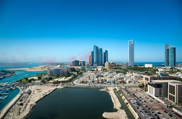 Gordijnen De skyline van Abu Dhabi met luchtshowkleuren in de lucht en uitzicht op de moderne gebouwen in de binnenstad © creativefamily