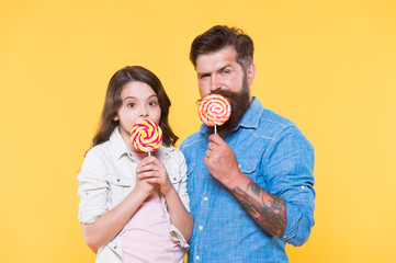 best taste ever. bearded hipster man is good dad. daddy and small girl kid love colorful lollipop....
