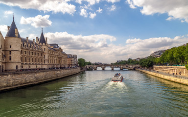 Cruise boat with tourists in a sunny spring day on Seine river in Paris, France.