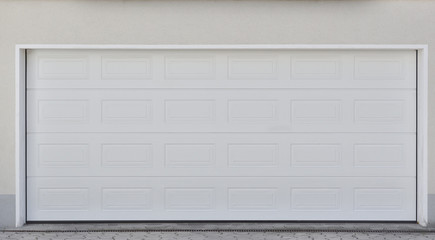 Wide white automatic garage door for two cars. Modern garage door