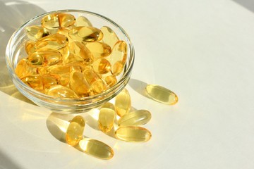 Omega 3 capsules lying on white background. Fish oil in pills. Health support and treatment. Biologically active additives. Selective focus.