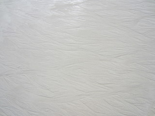 Mokry ubity piach na plaży z wzorem fal