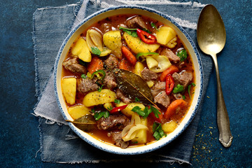 Beef stew with vegetables in a white bowl. Top view with copy space.