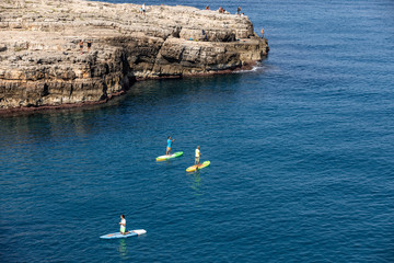  People are swimming along the cliff in Polignano a Mare.  Apulia, Bari province, Italy,
