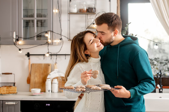young married couple baking cookies in the kitchen