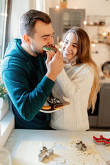 young married couple baking cookies in the kitchen