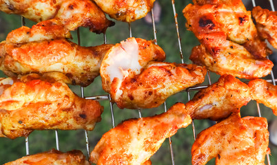 Cooking chicken skewers on the grill in the garden at sunset