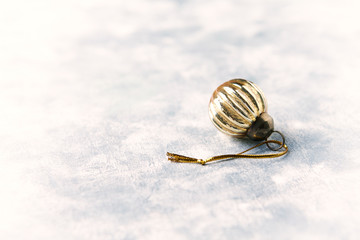 Christmas golden bauble on bright wooden background. Close up. Copy space. 