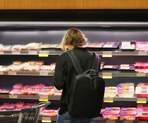 man purchasing a packet of meat at the supermarket